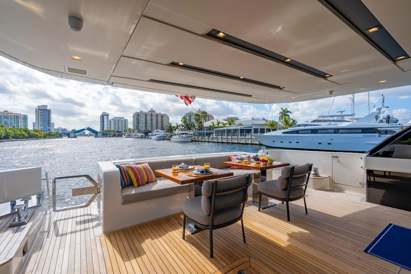 a large room with a table and chairs and a large city in the background aboard SWEET VIRGINIA Yacht for Sale
