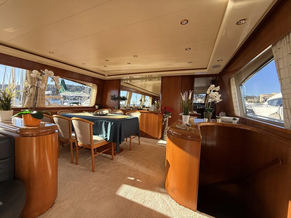 The yacht's salon features elegant wood finishes, ample seating, and large windows for natural light. aboard SIKOY Yacht for Sale