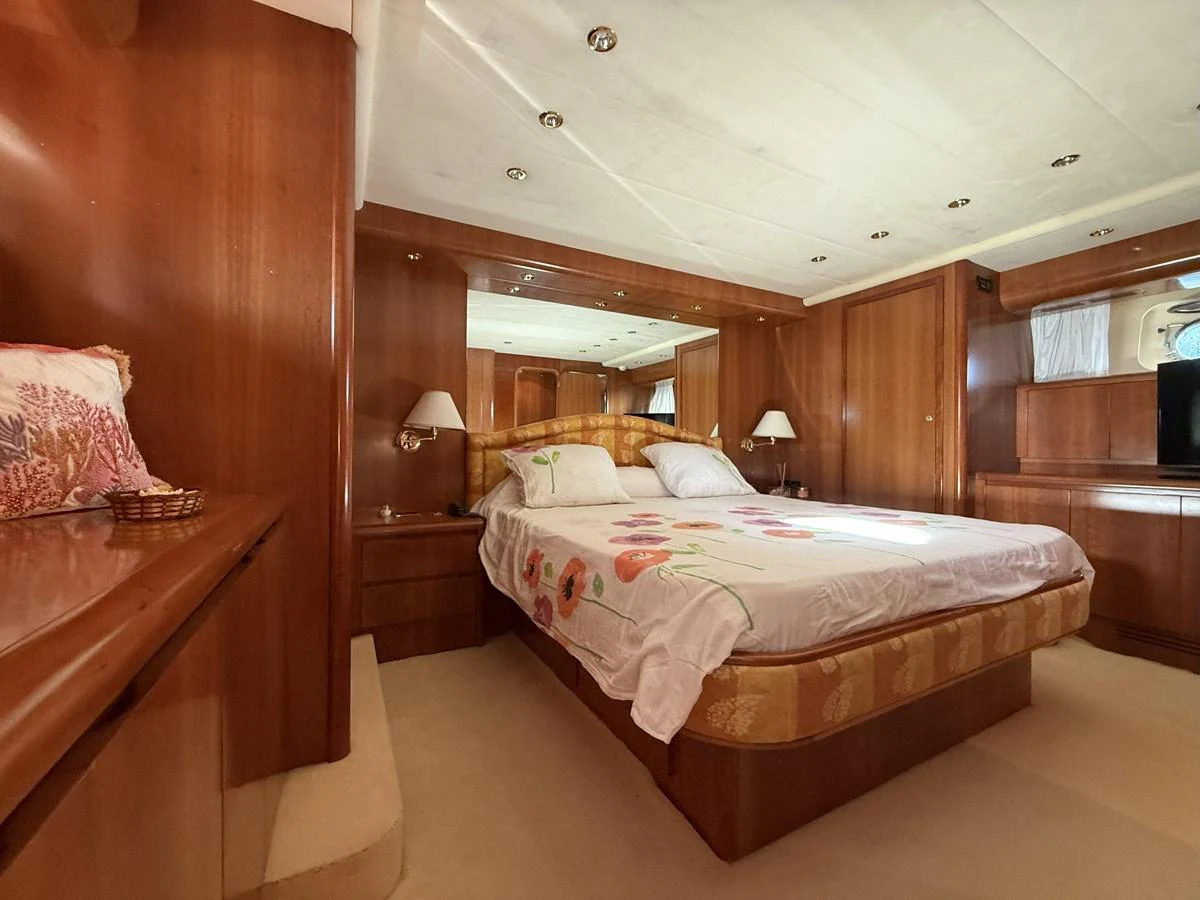 The master stateroom features a luxurious bed with elegant wooden furnishings and soft lighting. aboard SIKOY Yacht for Sale