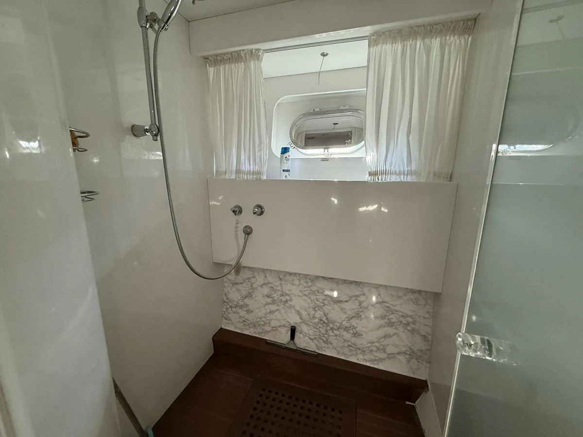 The yacht's bathroom features a clean, modern design with a marble accent wall and a large window for natural light. aboard SIKOY Yacht for Sale
