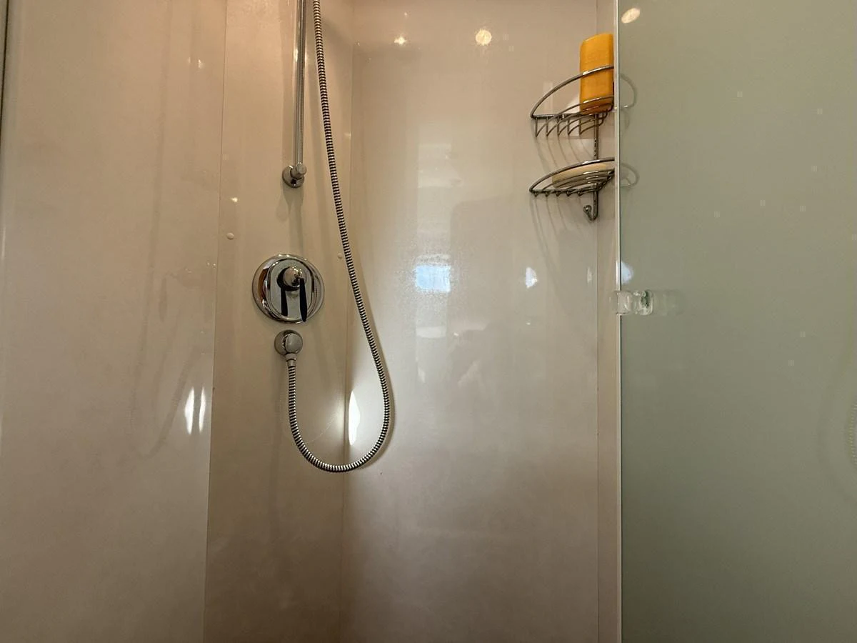 A sleek and modern shower area with a chrome showerhead and a glass door. aboard SIKOY Yacht for Sale