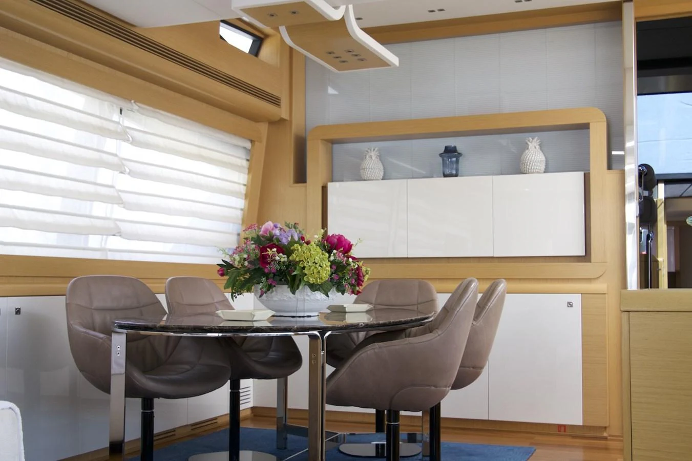 a dining table with chairs and a vase of flowers on it aboard ANTONINA Yacht for Sale