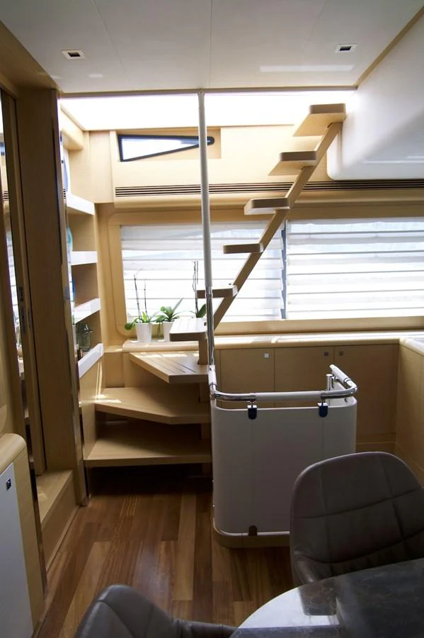 a room with a chair and a shelf with books on it aboard ANTONINA Yacht for Sale
