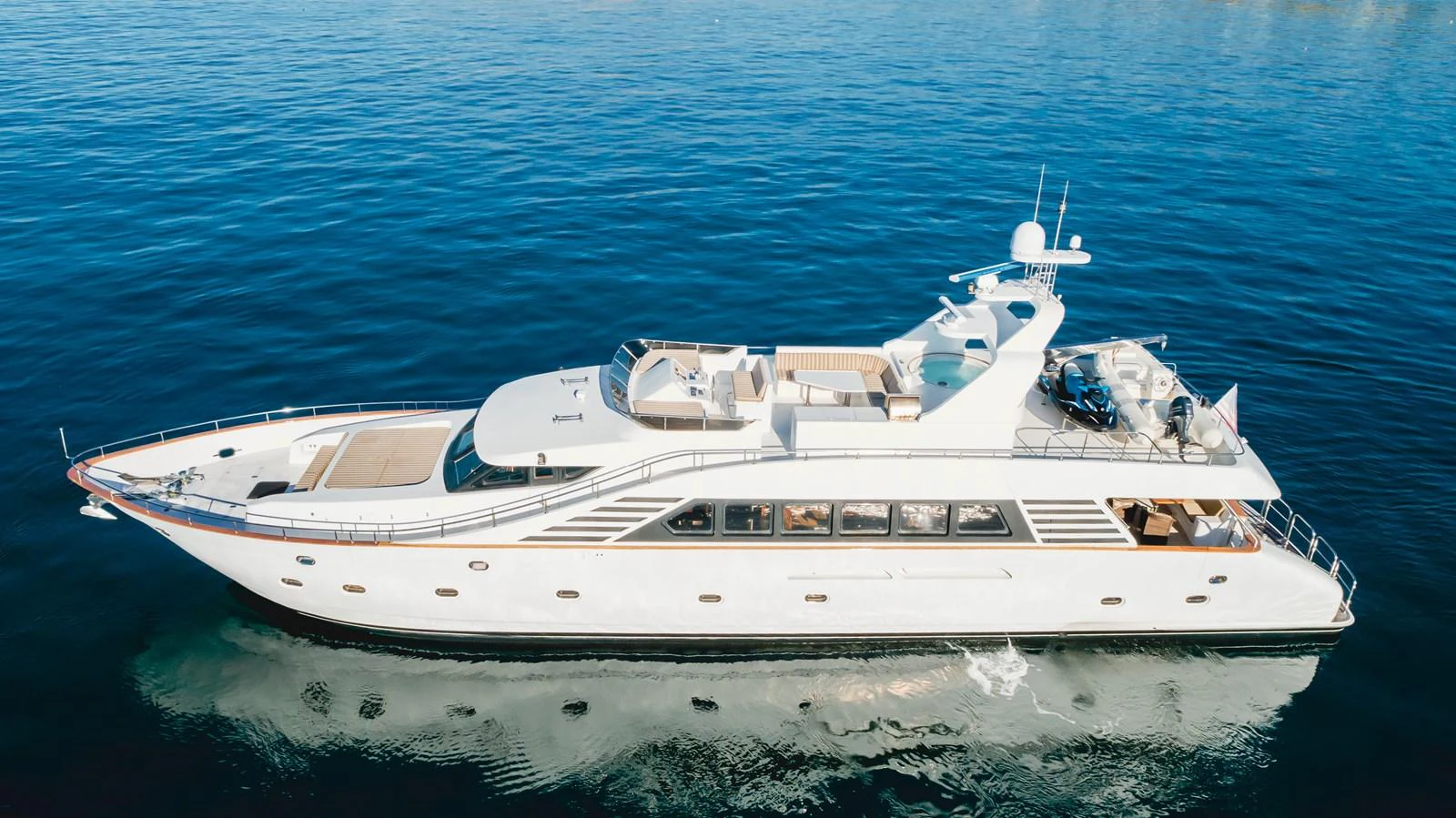 A sleek and elegant yacht glides smoothly on calm blue waters, showcasing its luxurious design and spacious decks. aboard MONEY CAT Yacht for Sale