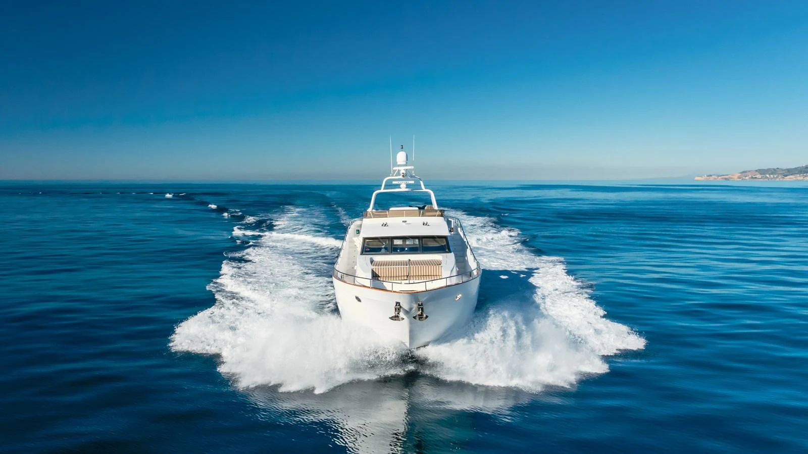A sleek yacht cruises swiftly through calm, open waters under a clear blue sky. aboard MONEY CAT Yacht for Sale