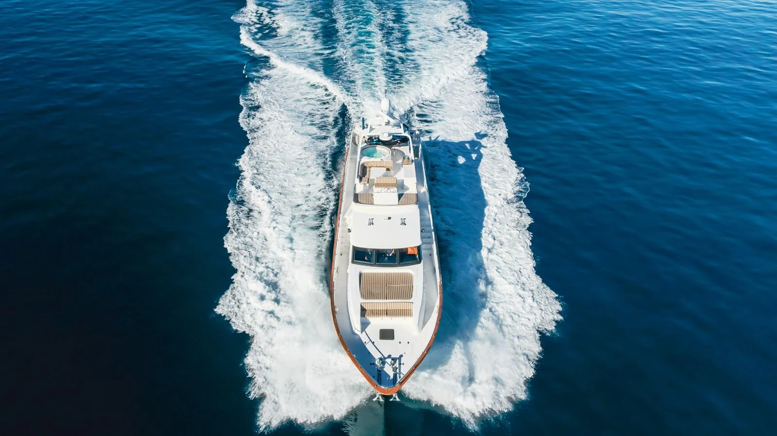 A luxurious yacht cruises through the open sea, leaving a trail of white wake behind. aboard MONEY CAT Yacht for Sale