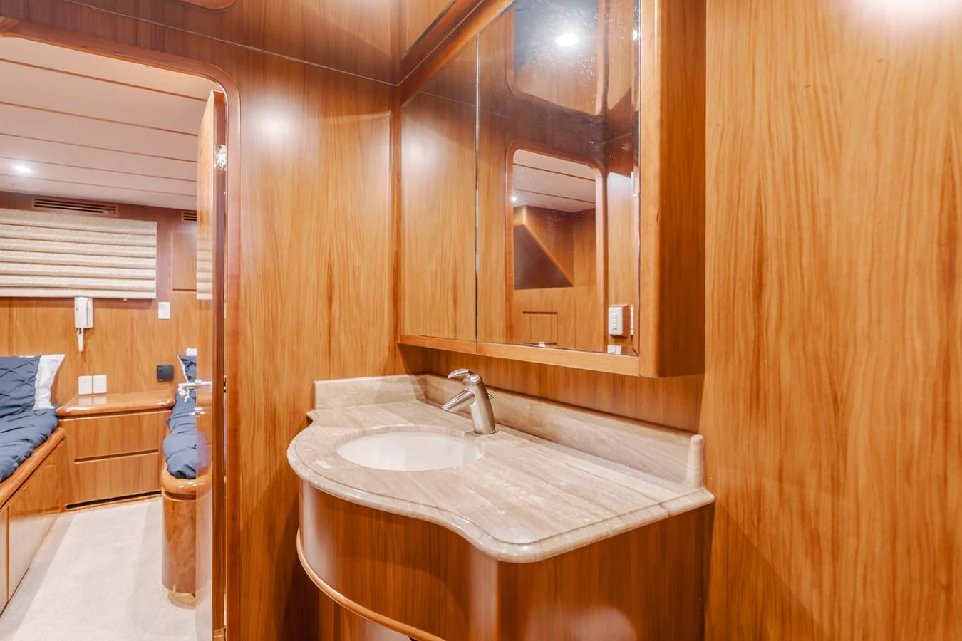 The yacht's bathroom features elegant wood paneling and a sleek countertop with a modern sink. aboard MONEY CAT Yacht for Sale