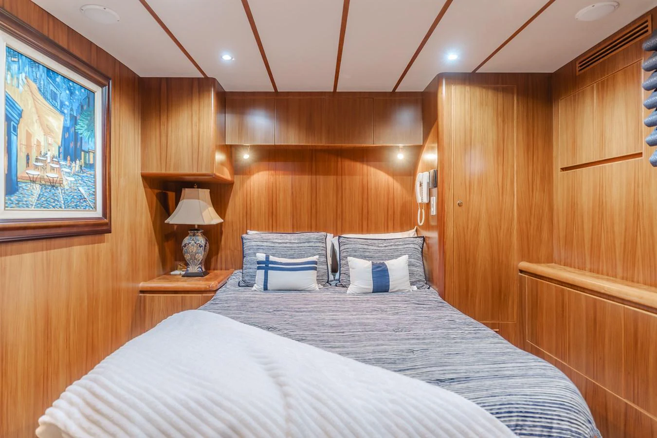 A cozy stateroom with warm wooden paneling and a comfortable bed. aboard MONEY CAT Yacht for Sale