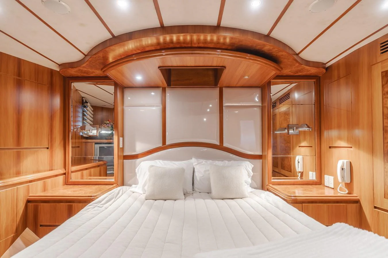 The stateroom features a luxurious bed with plush pillows and elegant wood paneling. aboard MONEY CAT Yacht for Sale