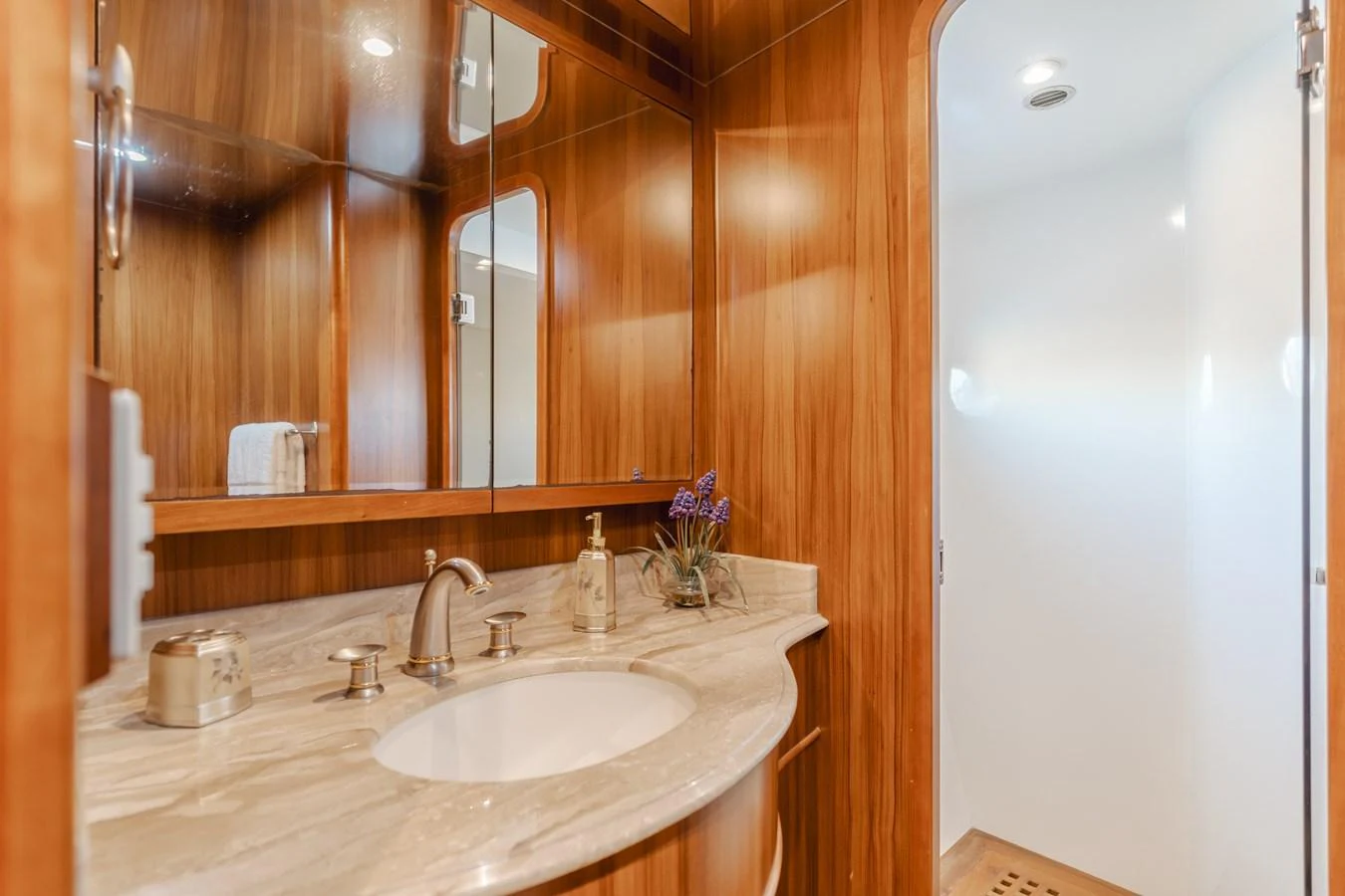 The yacht's bathroom features elegant wood paneling and a sleek marble countertop. aboard MONEY CAT Yacht for Sale