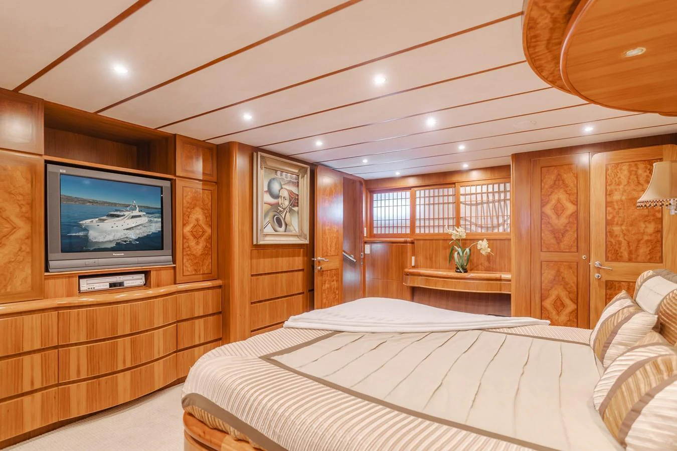 The master stateroom features luxurious wood paneling, a large bed, and a flat-screen TV for ultimate comfort. aboard MONEY CAT Yacht for Sale