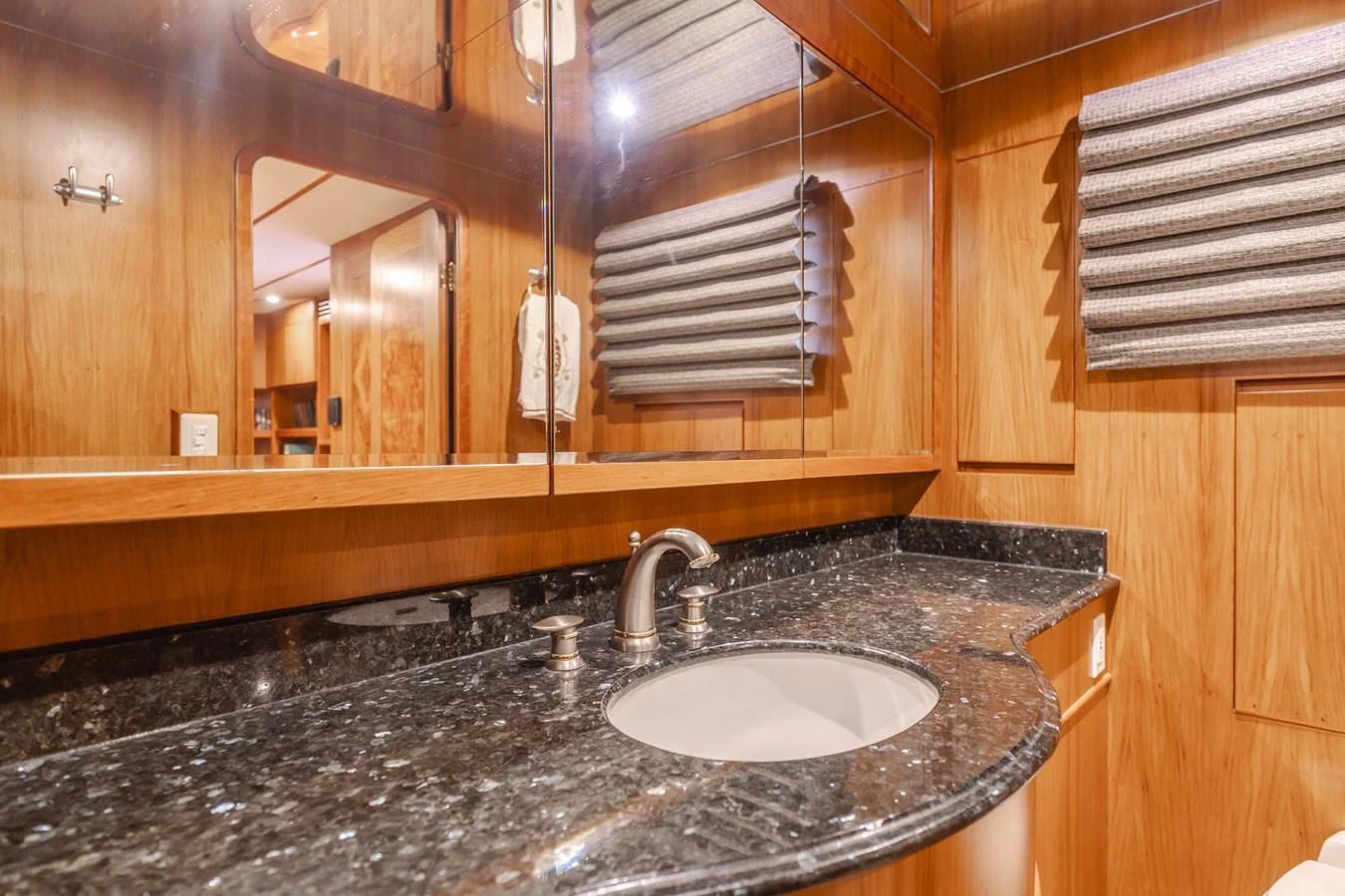 The yacht's bathroom features a sleek granite countertop and wooden cabinetry, creating a warm and inviting atmosphere. aboard MONEY CAT Yacht for Sale