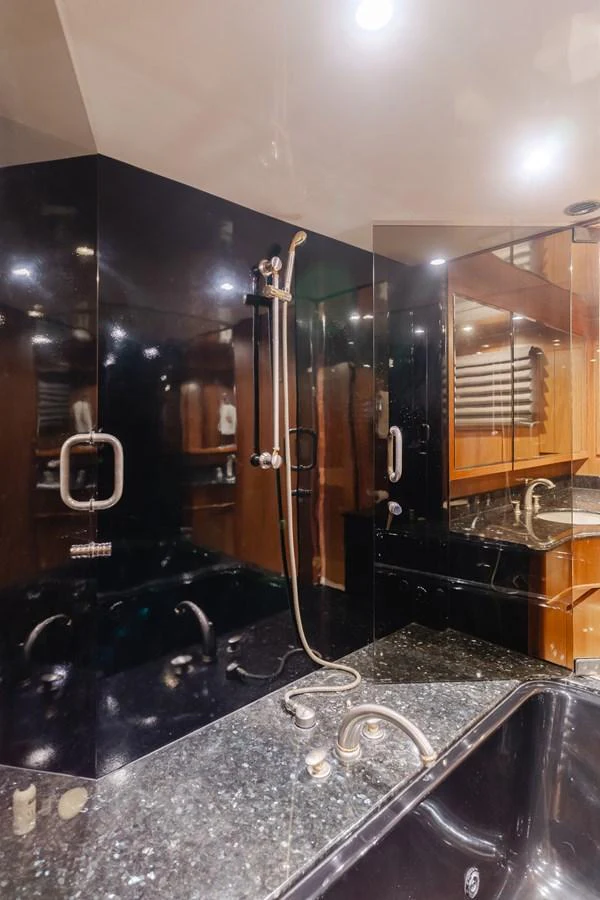 The yacht's bathroom features sleek black surfaces and modern fixtures, creating a luxurious and contemporary feel. aboard MONEY CAT Yacht for Sale