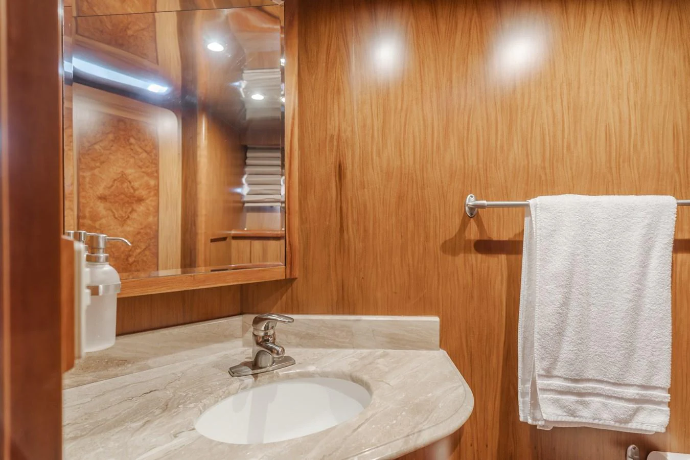 The yacht's bathroom features elegant wood paneling and a sleek marble countertop. aboard MONEY CAT Yacht for Sale