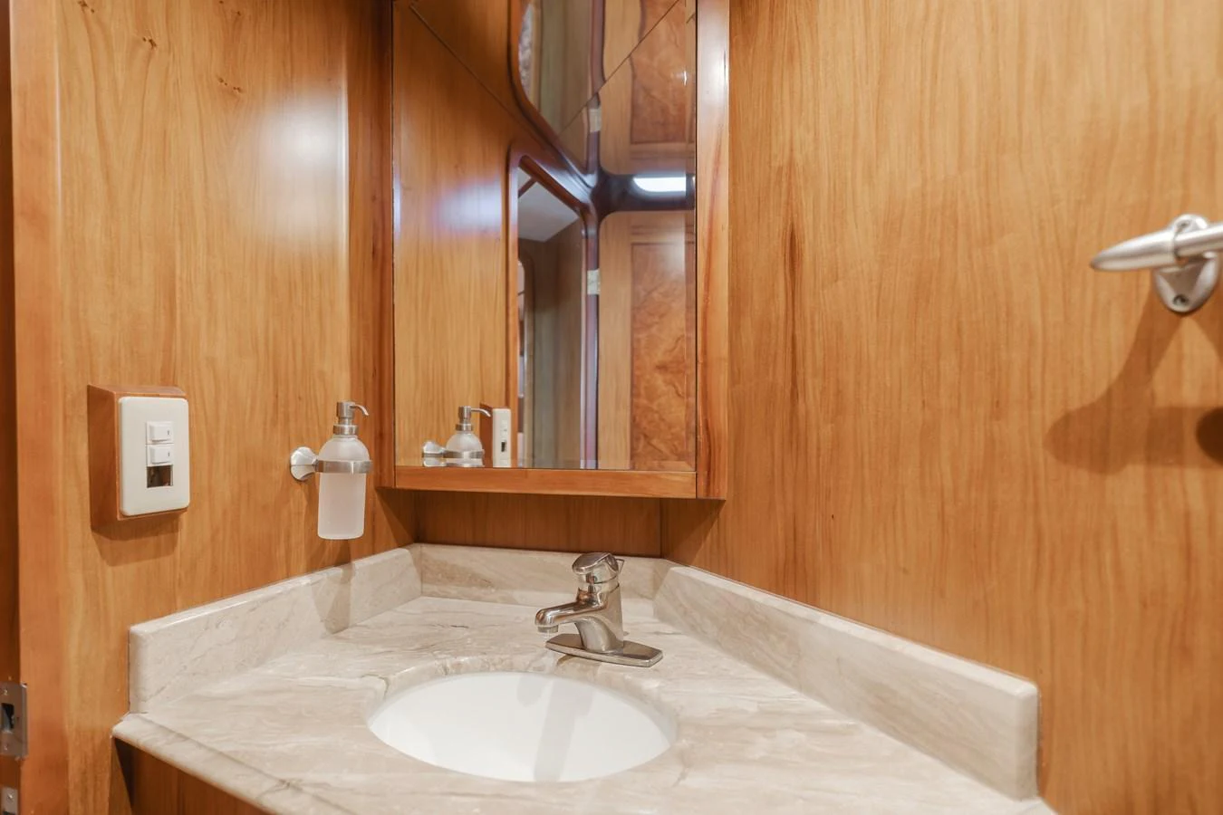 A well-appointed bathroom with a marble countertop and wooden paneling. aboard MONEY CAT Yacht for Sale