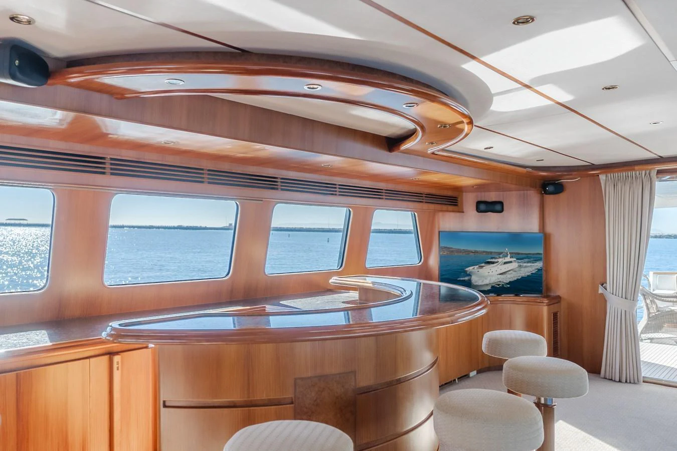 The yacht's salon features a stylish bar area with panoramic windows offering stunning sea views. aboard MONEY CAT Yacht for Sale