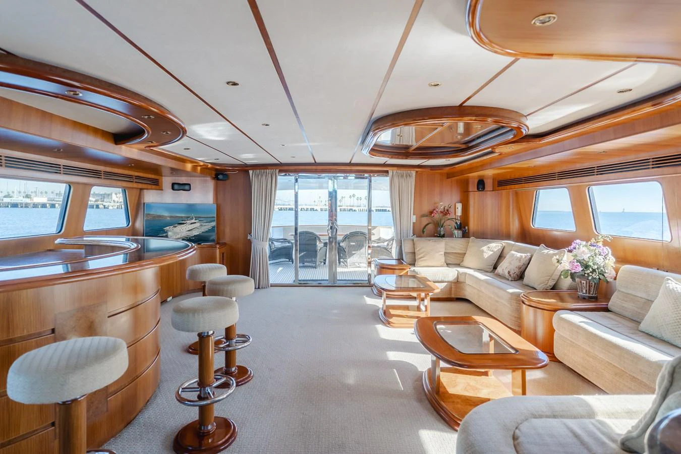 The salon features plush seating, a bar area, and large windows offering panoramic views. aboard MONEY CAT Yacht for Sale