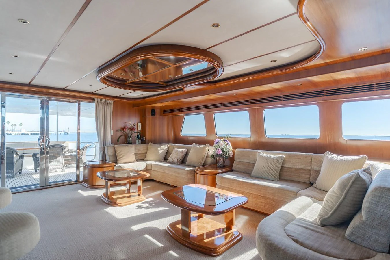 The salon features plush seating, elegant wooden accents, and large windows offering stunning ocean views. aboard MONEY CAT Yacht for Sale