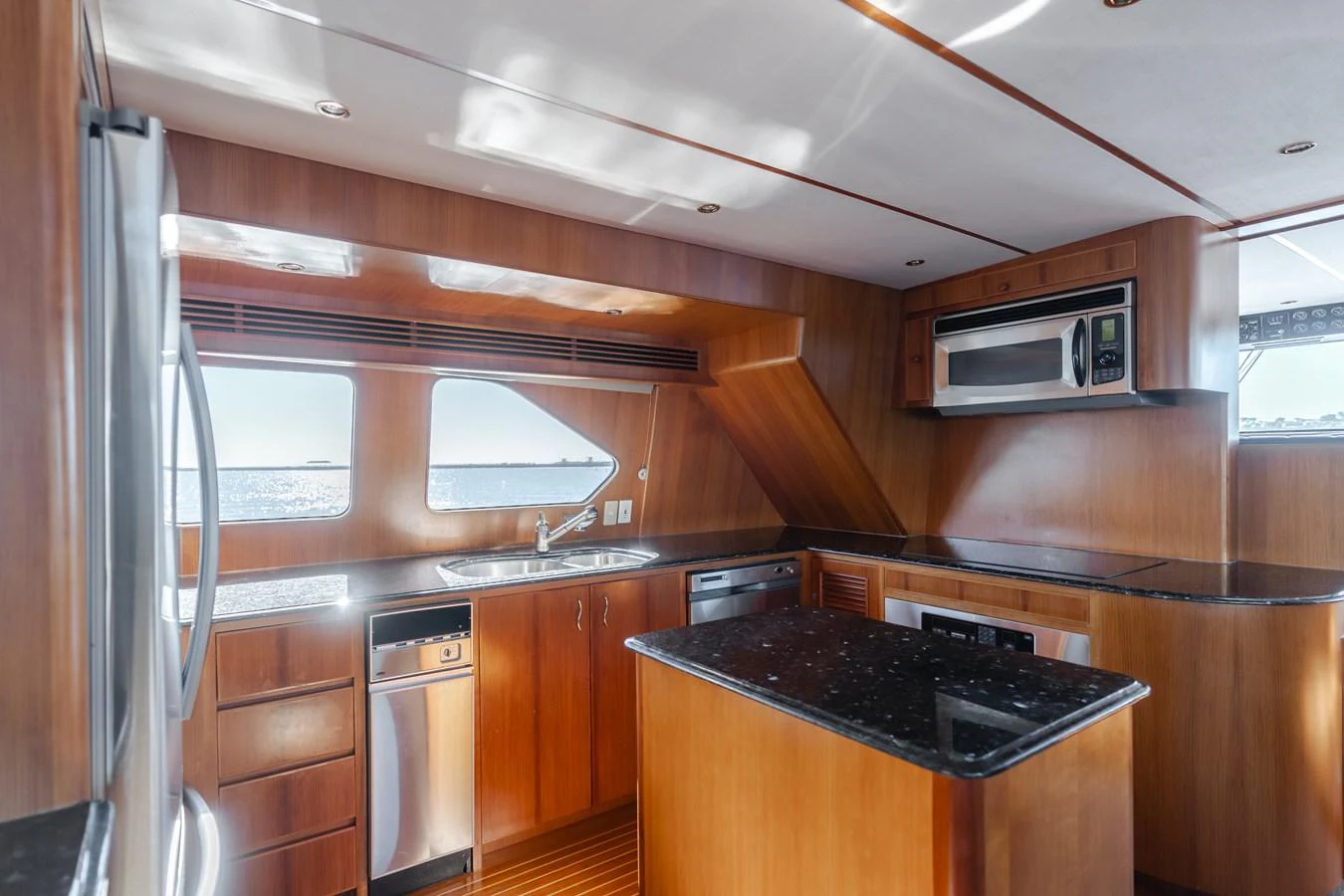 The yacht's galley features sleek wooden cabinetry and modern stainless steel appliances. aboard MONEY CAT Yacht for Sale
