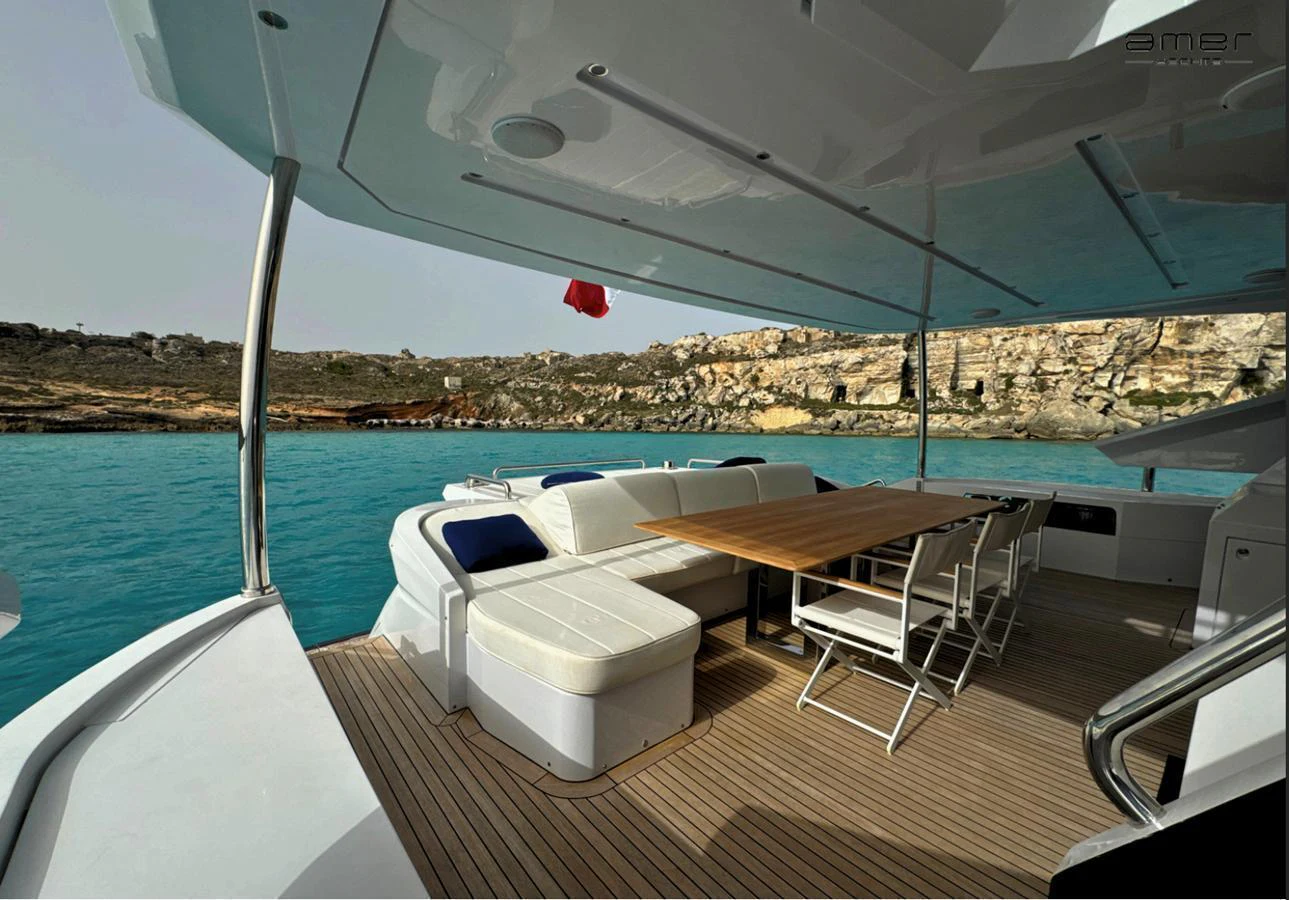 The aft deck offers a spacious and comfortable seating area with a dining table, perfect for enjoying meals with a view of the water. aboard ALTUS Yacht for Sale