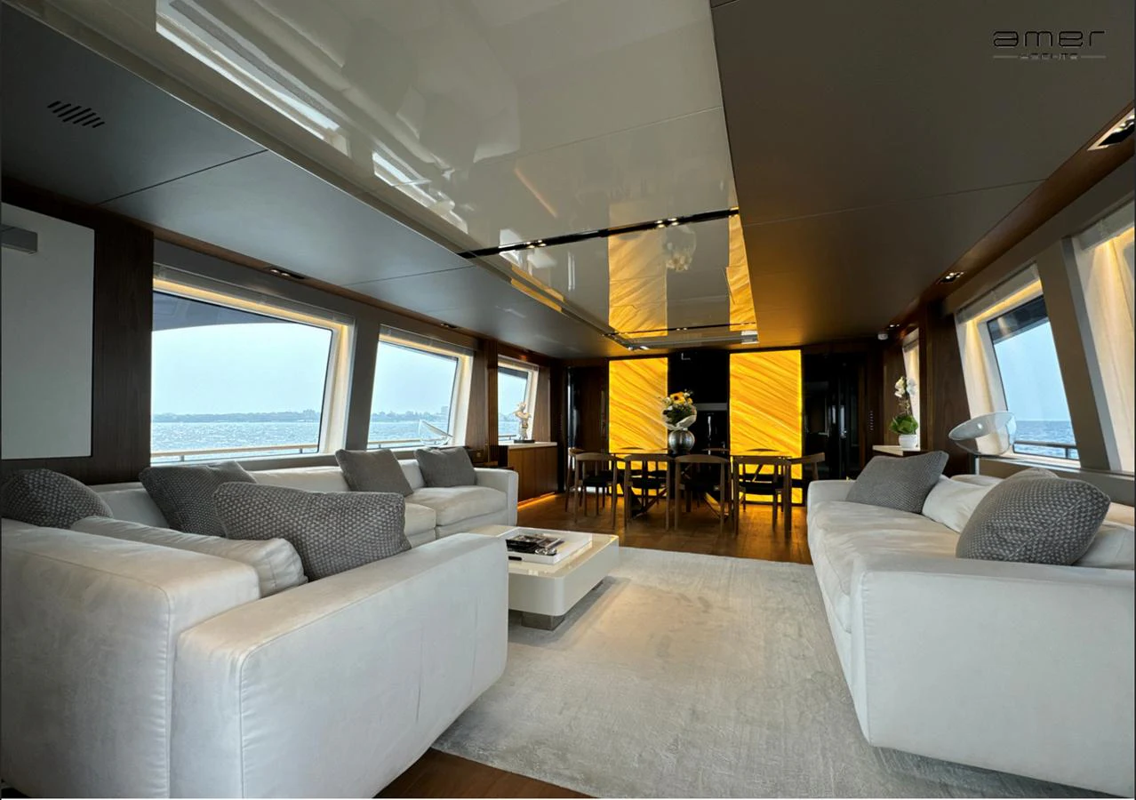 The yacht's salon features luxurious seating with panoramic windows offering stunning views. aboard ALTUS Yacht for Sale