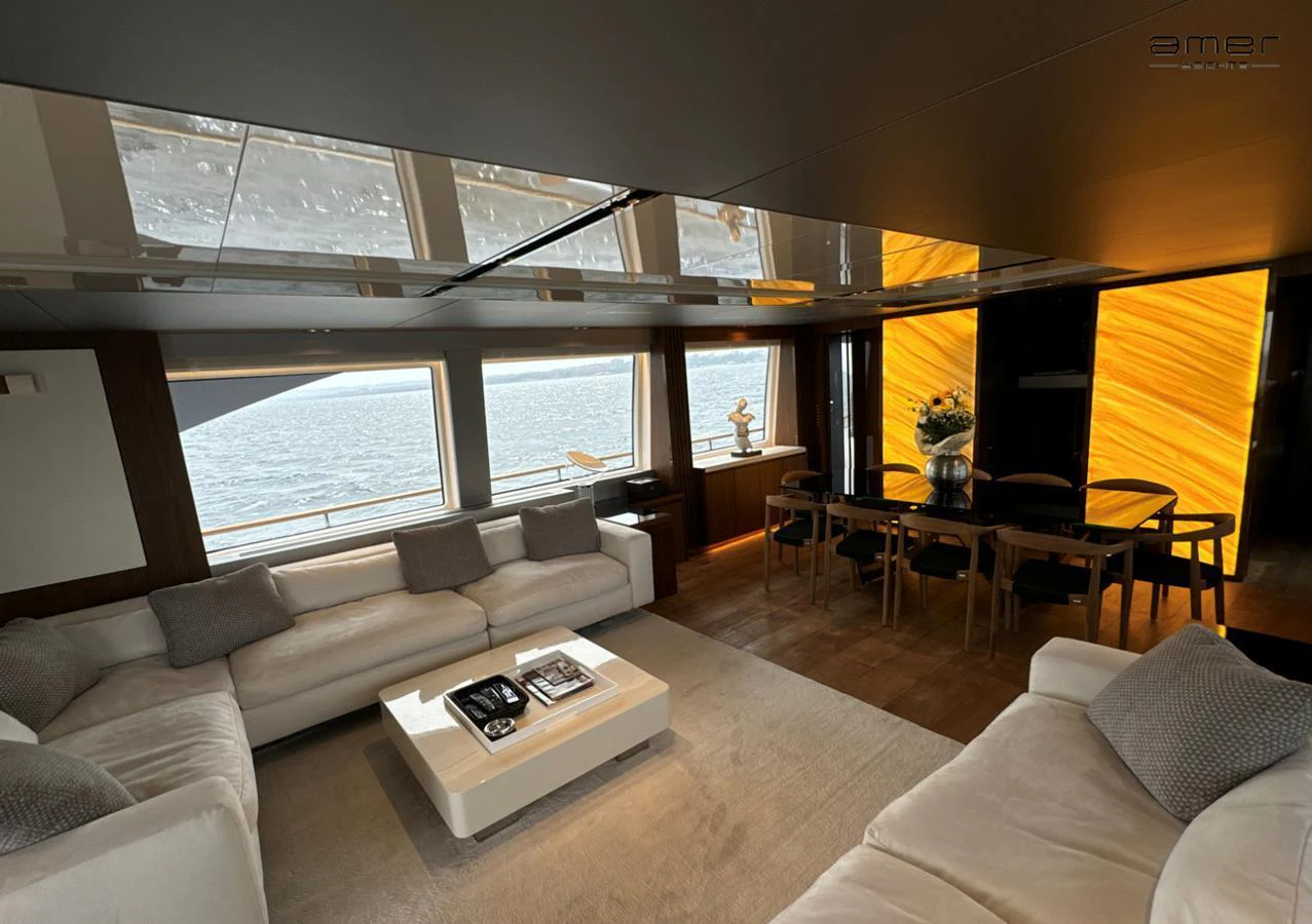 The salon features luxurious seating with panoramic windows offering stunning sea views. aboard ALTUS Yacht for Sale