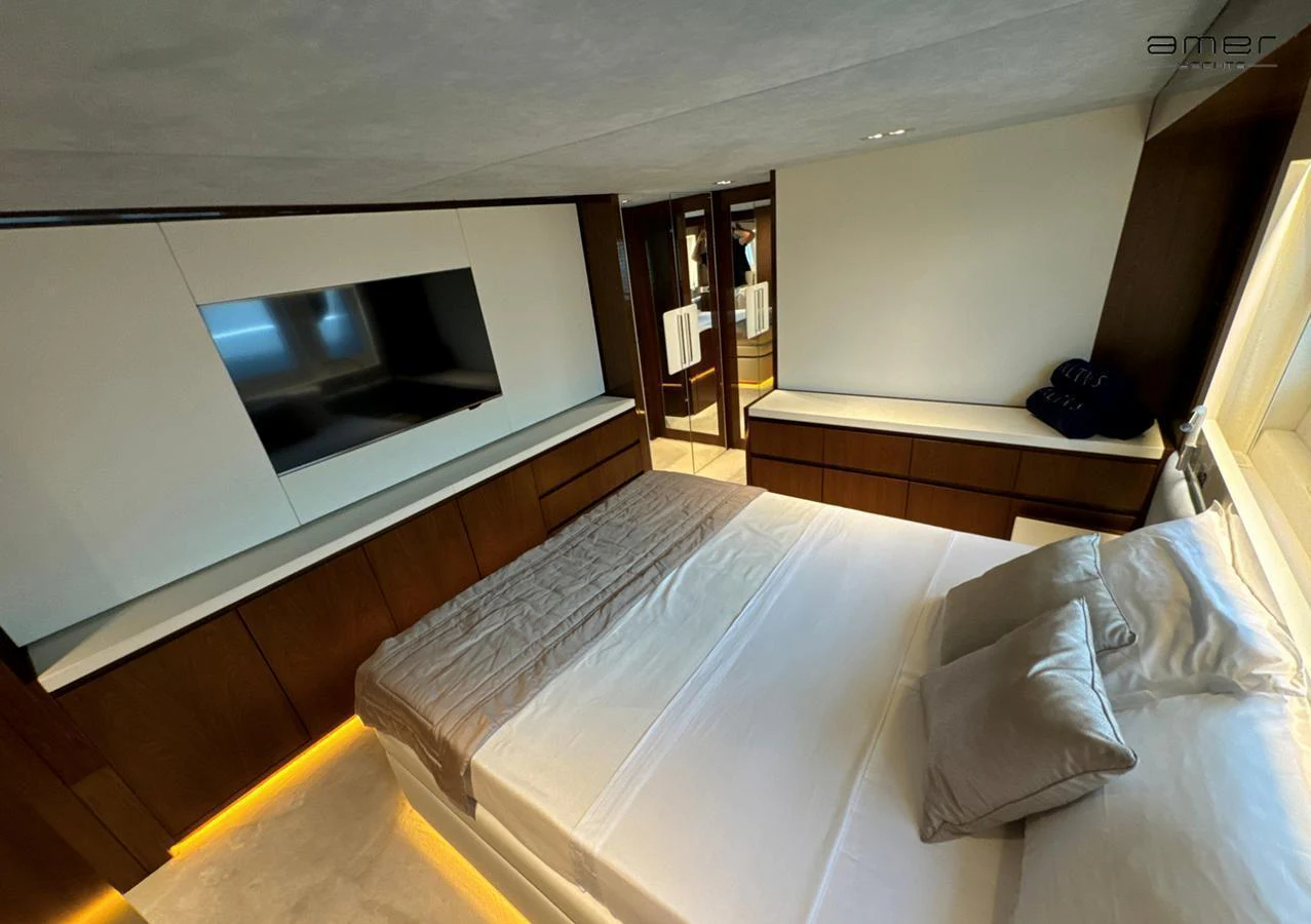 The stateroom features a modern design with a large bed, ample storage, and a flat-screen TV. aboard ALTUS Yacht for Sale