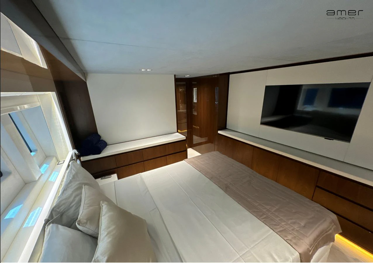 A luxurious stateroom featuring a large bed, ample storage, and a flat-screen TV. aboard ALTUS Yacht for Sale