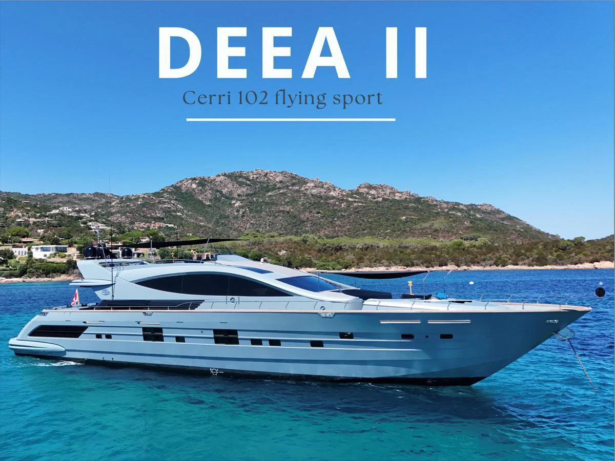A sleek and modern yacht glides gracefully on clear blue waters with a scenic coastal backdrop. aboard DEEA II Yacht for Sale