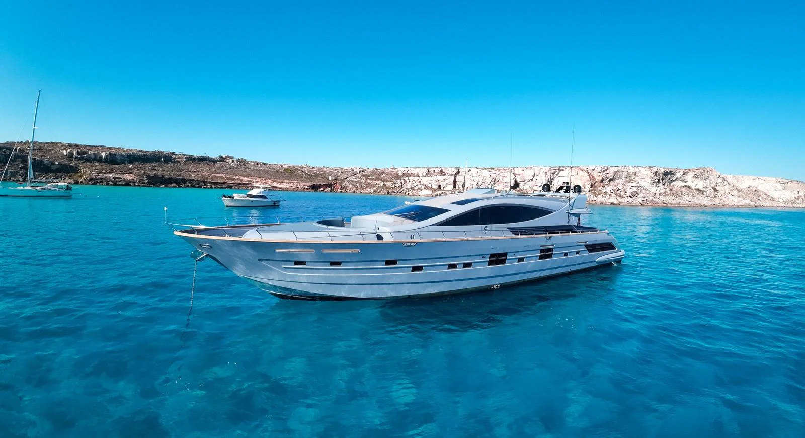 A sleek and modern yacht glides gracefully on clear blue waters, showcasing its elegant design. aboard DEEA II Yacht for Sale