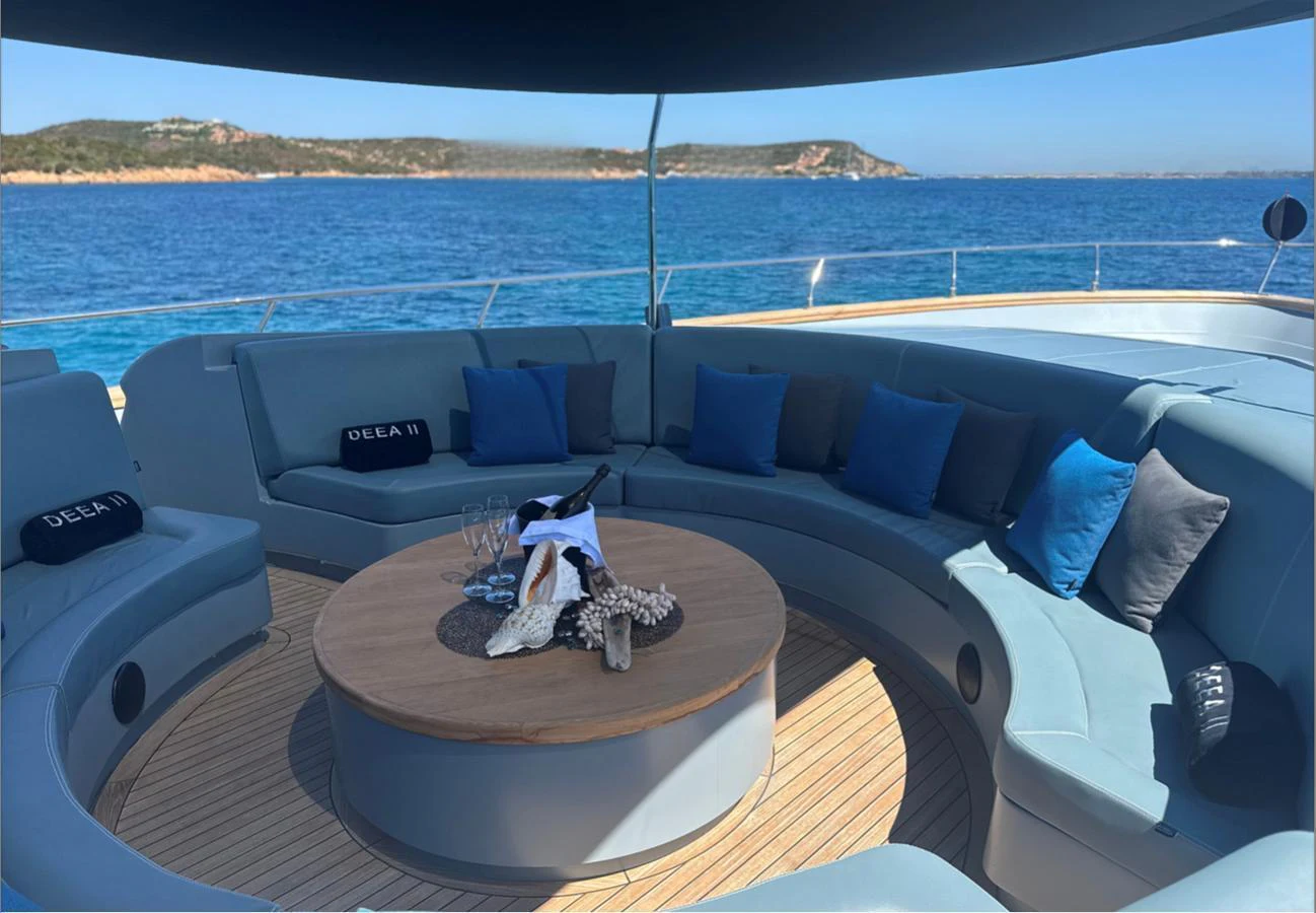 The sundeck offers a luxurious seating area with a central table, perfect for relaxation and socializing. aboard DEEA II Yacht for Sale