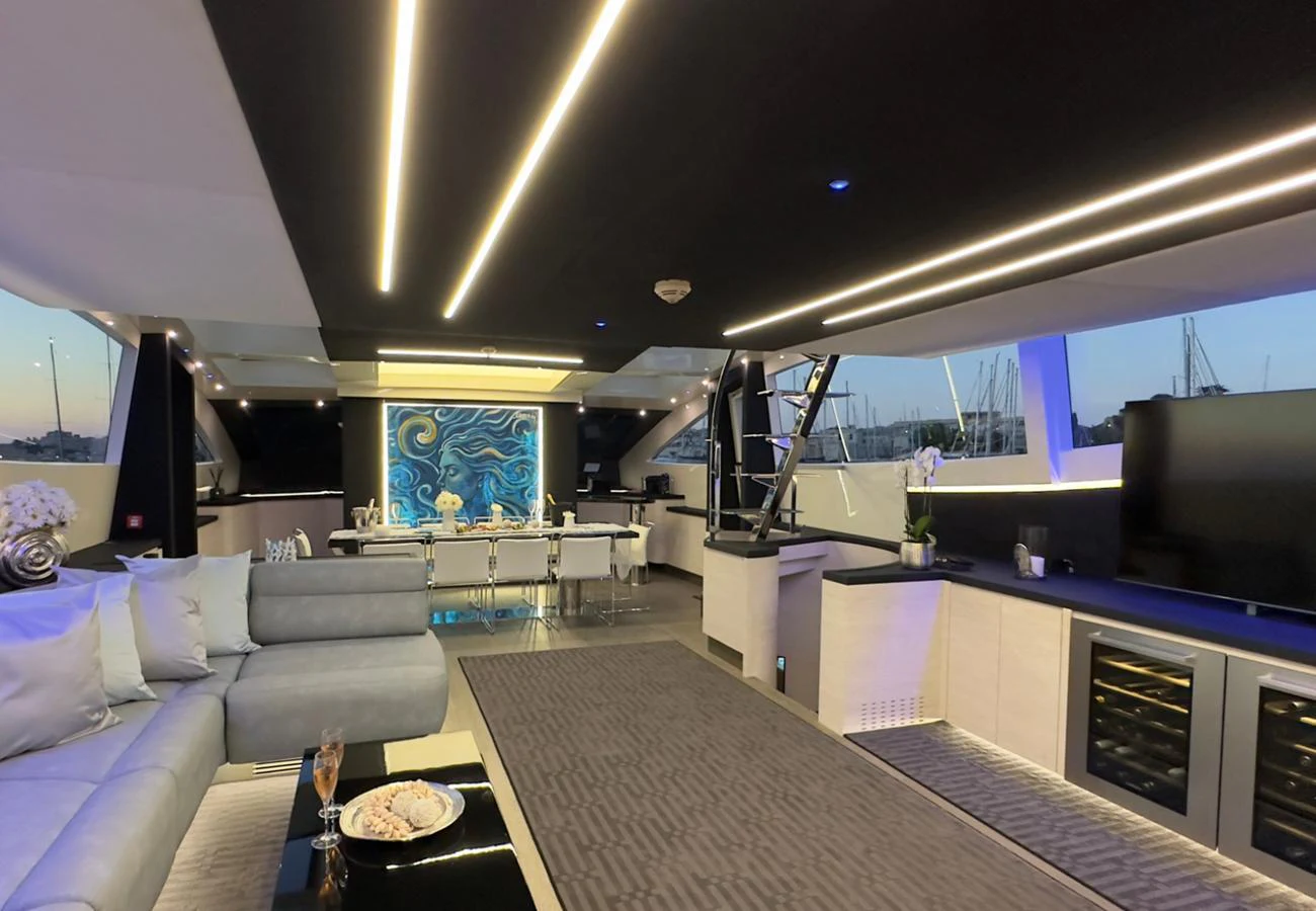 The yacht's interior features a modern, open-plan living space with luxurious furnishings and ambient lighting. aboard DEEA II Yacht for Sale