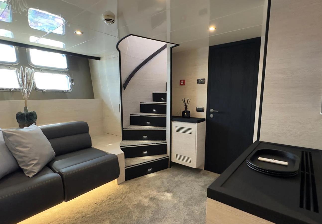 The yacht's salon features modern furnishings and a staircase leading to the upper deck. aboard DEEA II Yacht for Sale