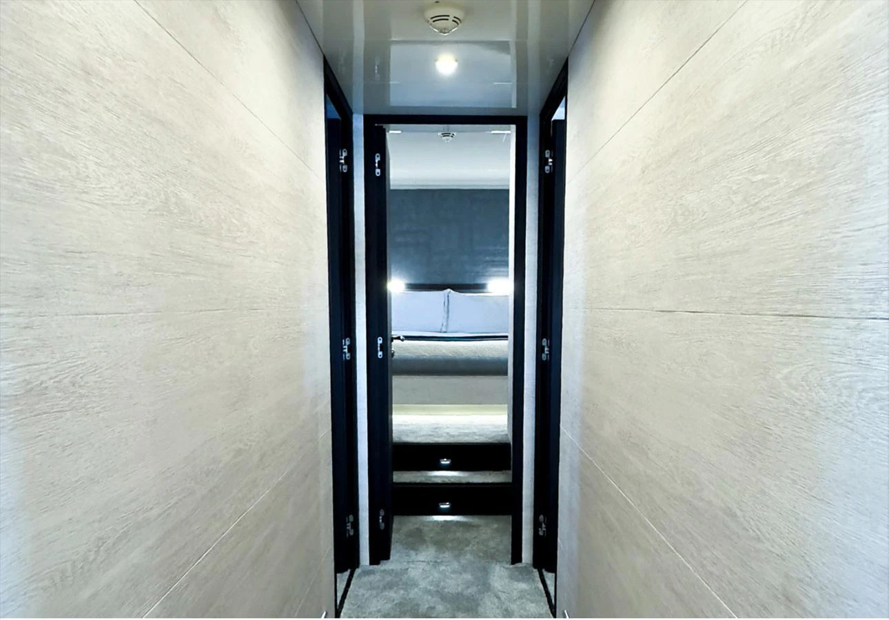 A sleek hallway leading to a cozy stateroom with modern lighting. aboard DEEA II Yacht for Sale