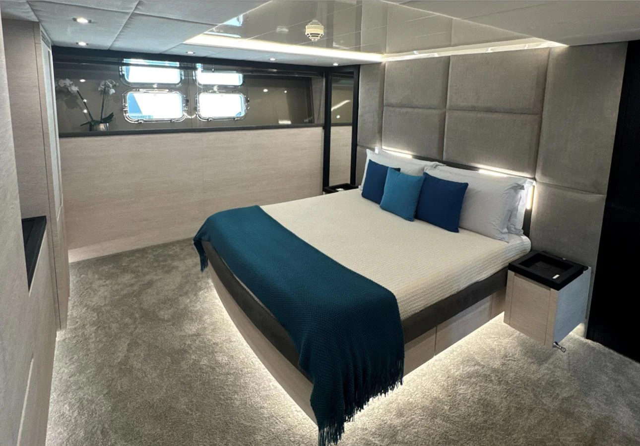 A luxurious stateroom featuring a large bed with blue accents and modern lighting. aboard DEEA II Yacht for Sale