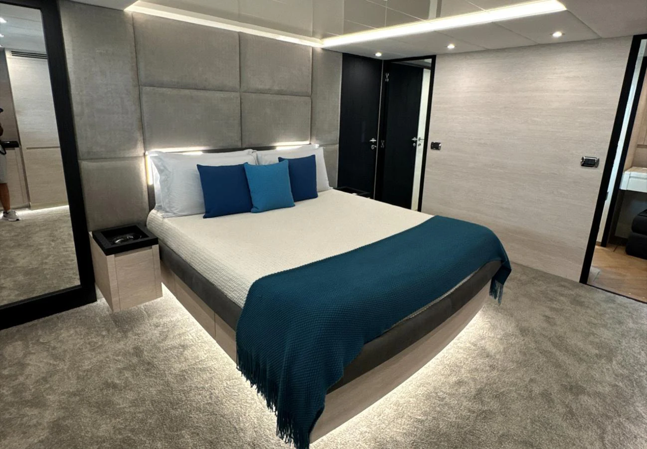 A luxurious stateroom featuring a large bed with elegant bedding and ambient lighting. aboard DEEA II Yacht for Sale