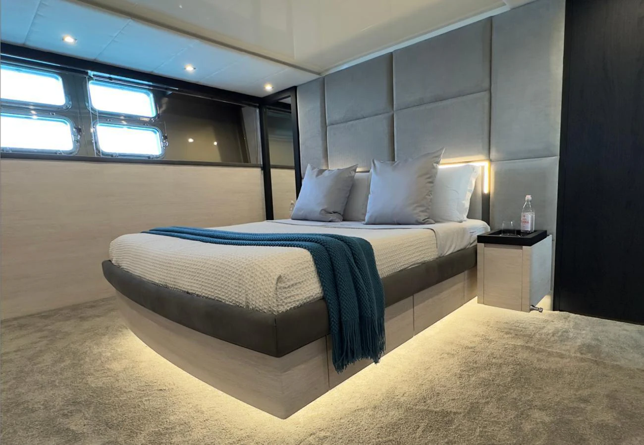 A luxurious stateroom featuring a modern bed with ambient lighting and elegant decor. aboard DEEA II Yacht for Sale