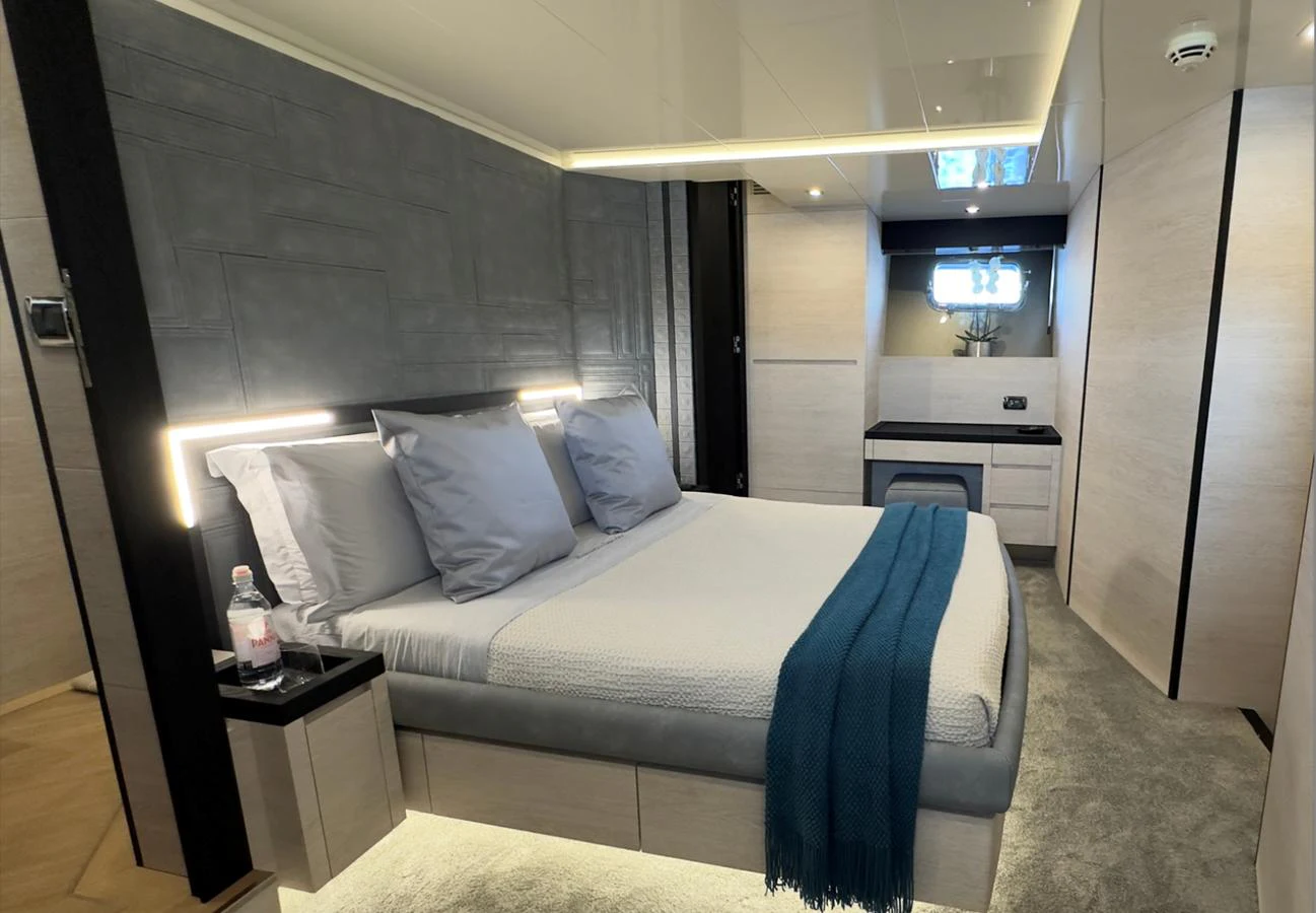 The stateroom features a modern design with a comfortable bed and ambient lighting. aboard DEEA II Yacht for Sale