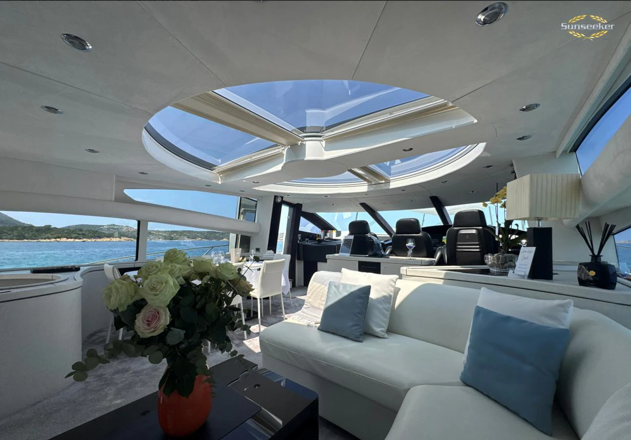 a room with a couch and a table with chairs and a vase of flowers aboard LIGHT BLUE Yacht for Sale