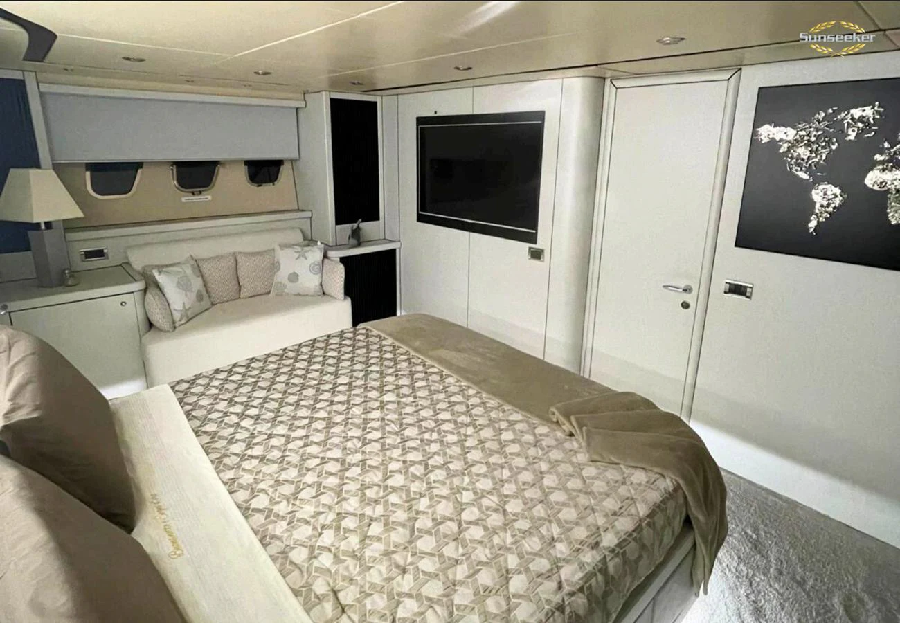 a room with a bed and a television aboard LIGHT BLUE Yacht for Sale