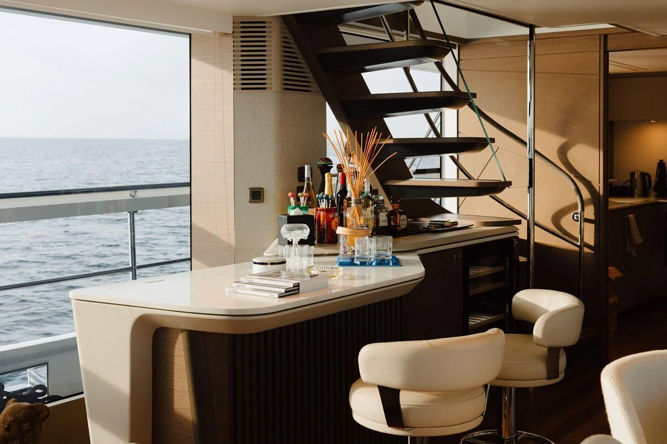 A stylish bar area with a modern staircase and ocean view. aboard PRINCESS X95 808 Yacht for Sale