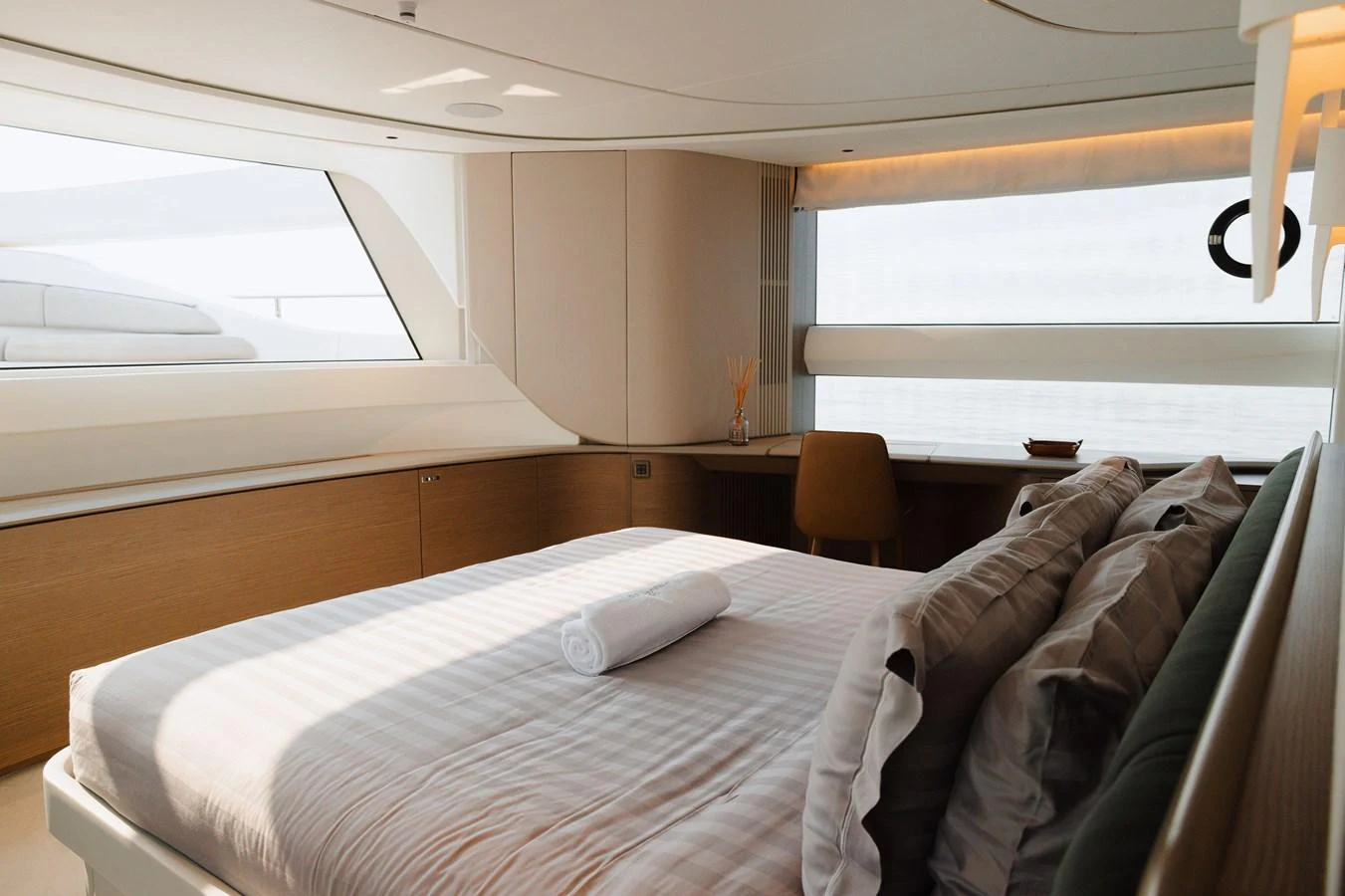 A luxurious stateroom featuring a large bed with plush pillows and a window offering natural light. aboard PRINCESS X95 808 Yacht for Sale
