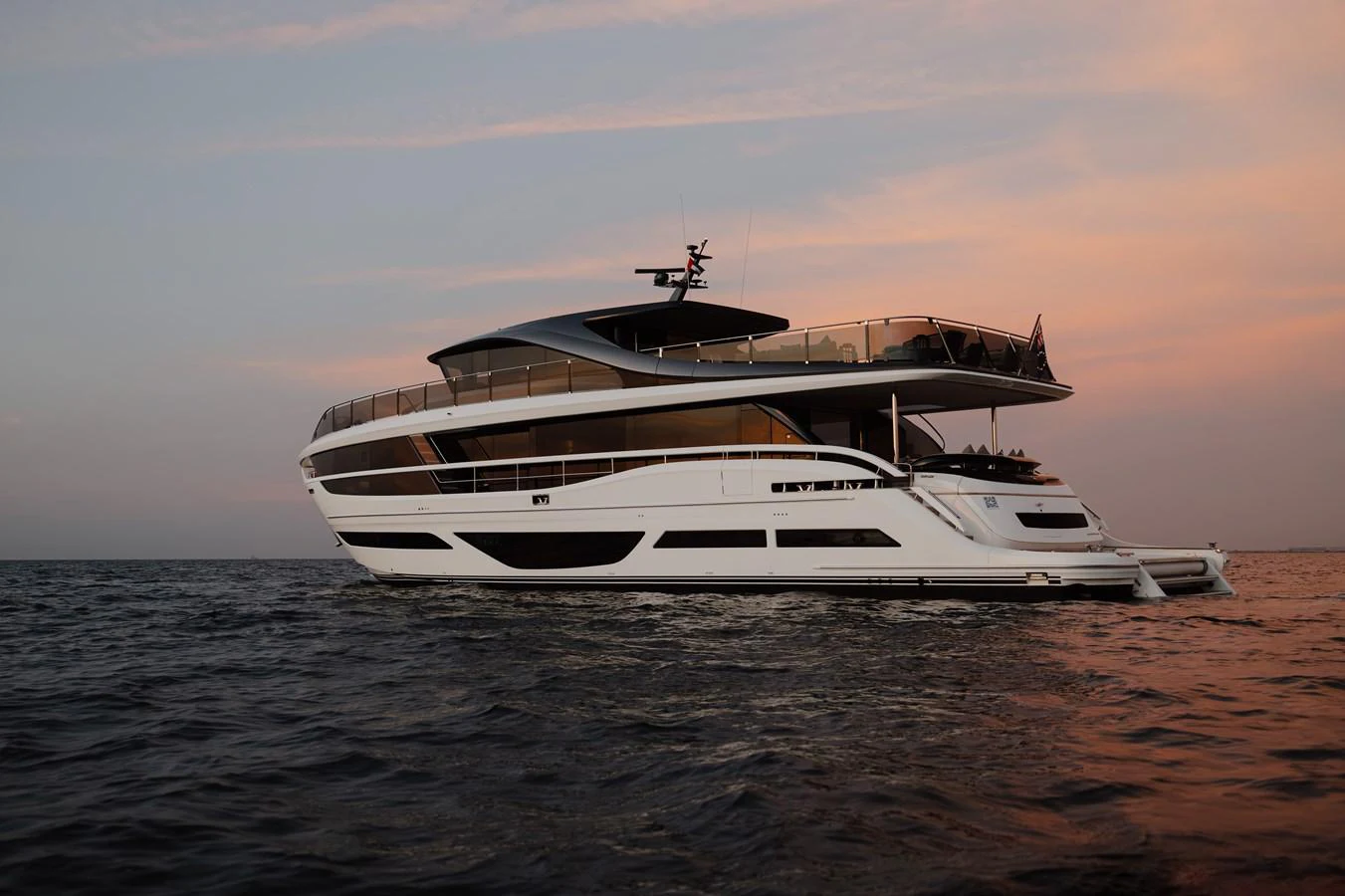 A sleek and modern yacht cruises on calm waters at sunset. aboard PRINCESS X95 808 Yacht for Sale
