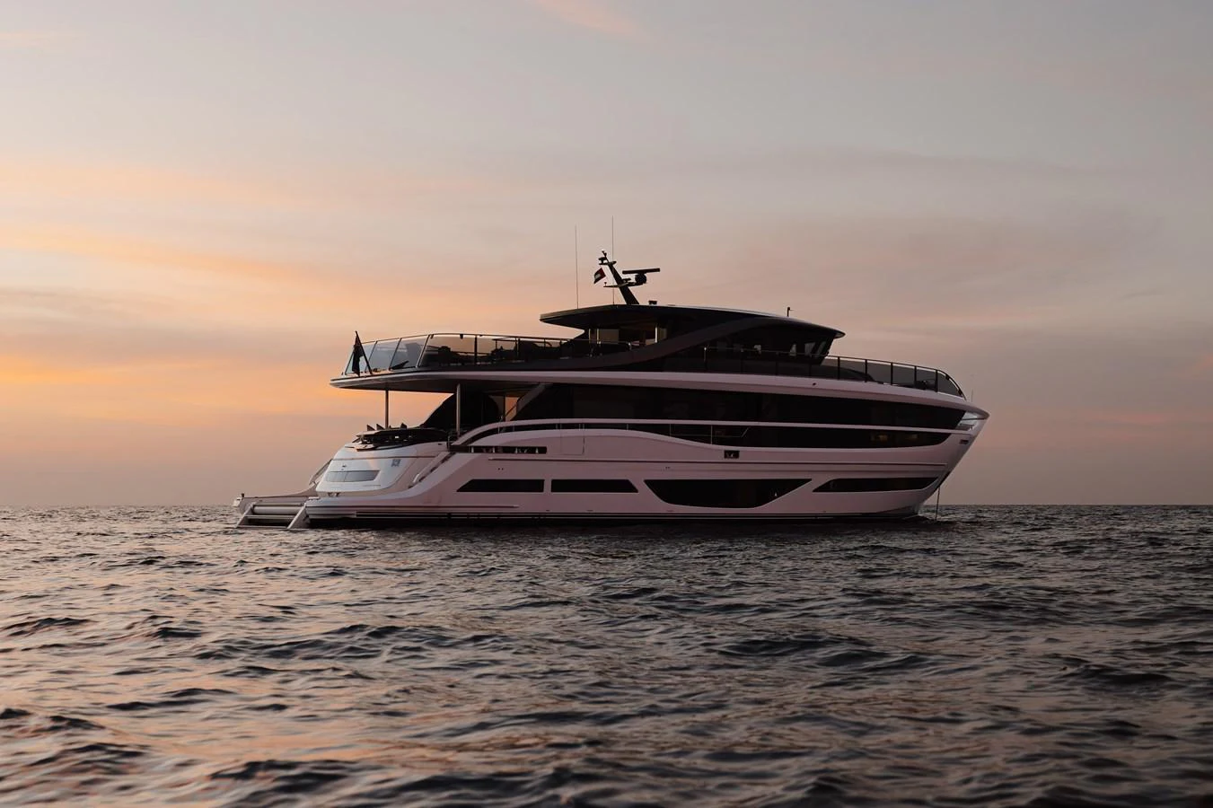 A sleek and modern yacht glides gracefully on the water at sunset. aboard PRINCESS X95 808 Yacht for Sale