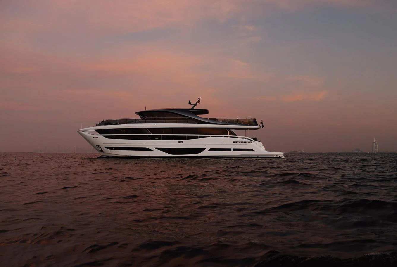 A sleek and modern yacht glides gracefully on calm waters at sunset. aboard PRINCESS X95 808 Yacht for Sale