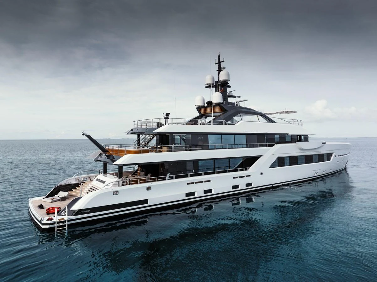 A sleek and modern yacht cruising on calm waters under a cloudy sky. aboard ENTOURAGE Yacht for Sale