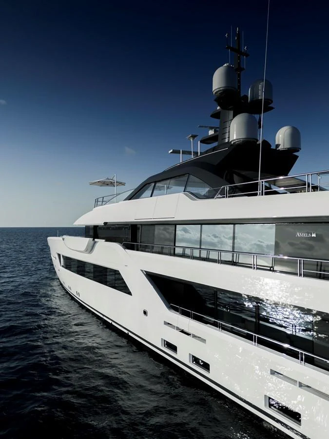 A sleek and modern yacht cruising on the open sea under a clear sky. aboard ENTOURAGE Yacht for Sale