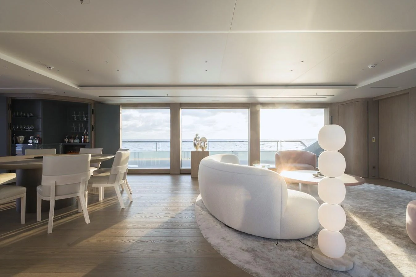 The salon features modern furnishings with ample natural light and a serene ocean view. aboard ENTOURAGE Yacht for Sale