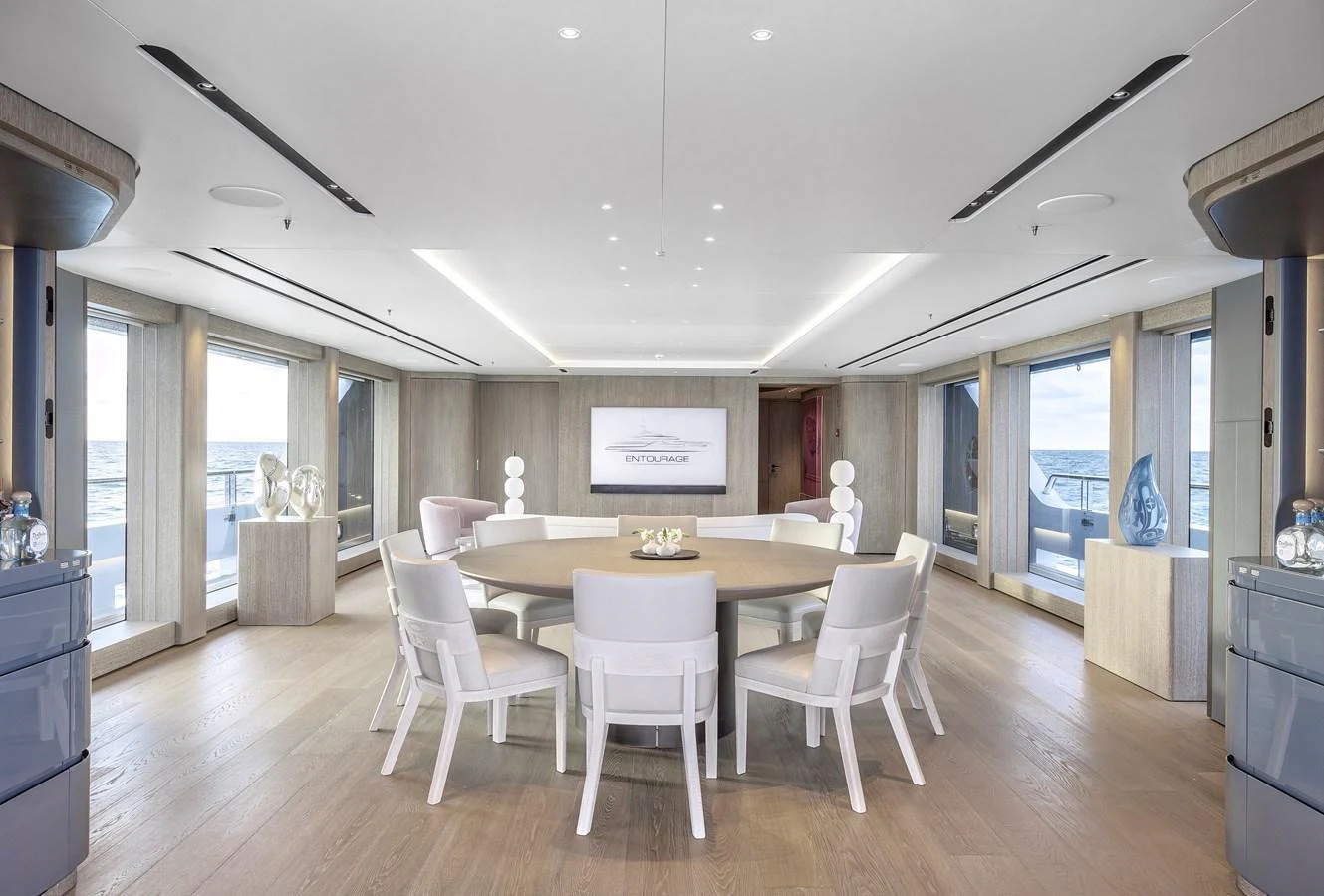 A spacious and elegantly designed dining area with panoramic views and modern furnishings. aboard ENTOURAGE Yacht for Sale