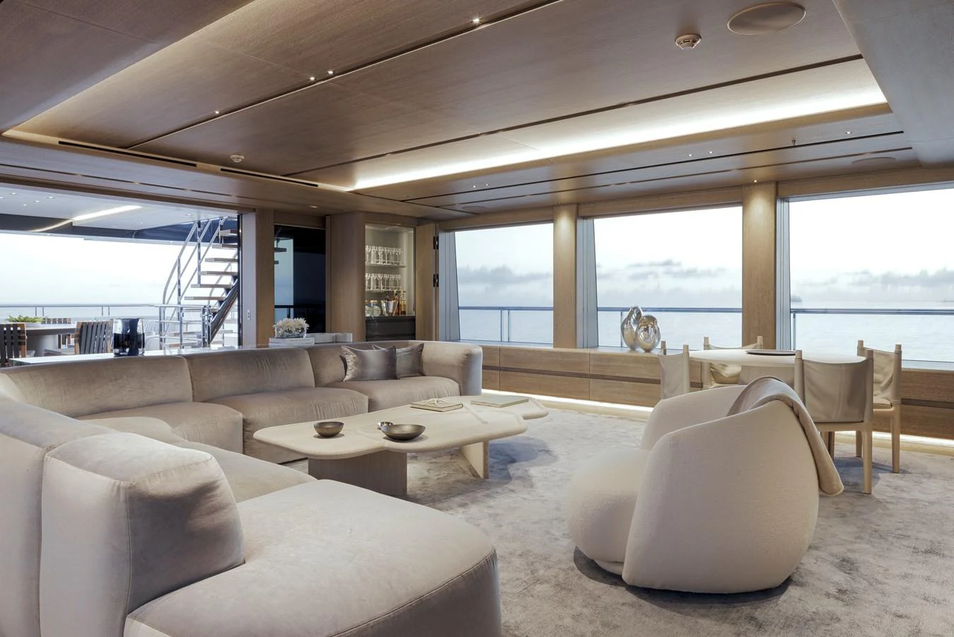 The salon features luxurious seating with panoramic ocean views through large windows. aboard ENTOURAGE Yacht for Sale